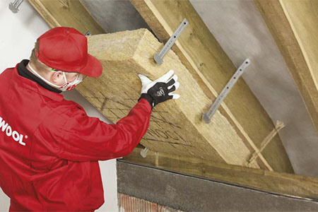 Układanie pierwszej warstwy wełny skalnej ROCKWOOL między krokwiami
